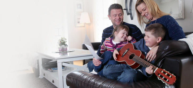 Bilde av to voksne og to barn i en sofa